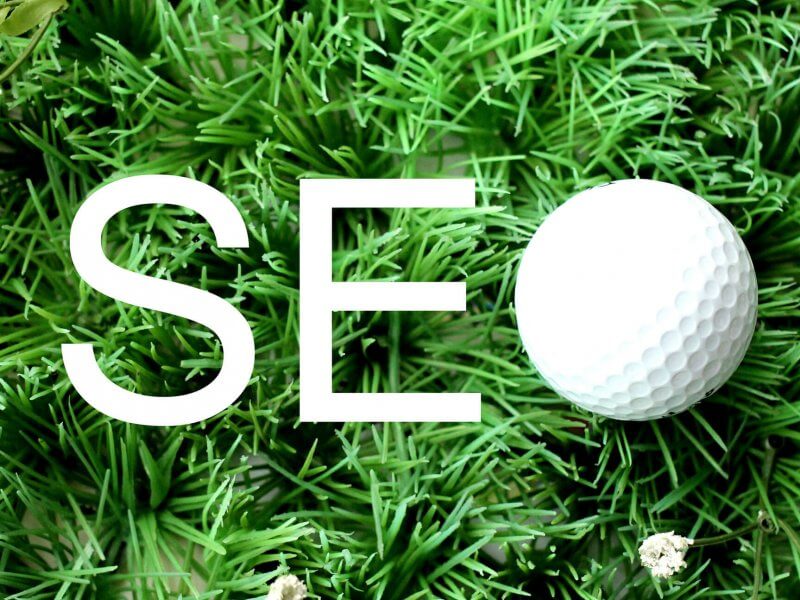 Le mot « SEO » (ou « référencement naturel ») formé par une balle de golf posée sur du gazon artificiel.